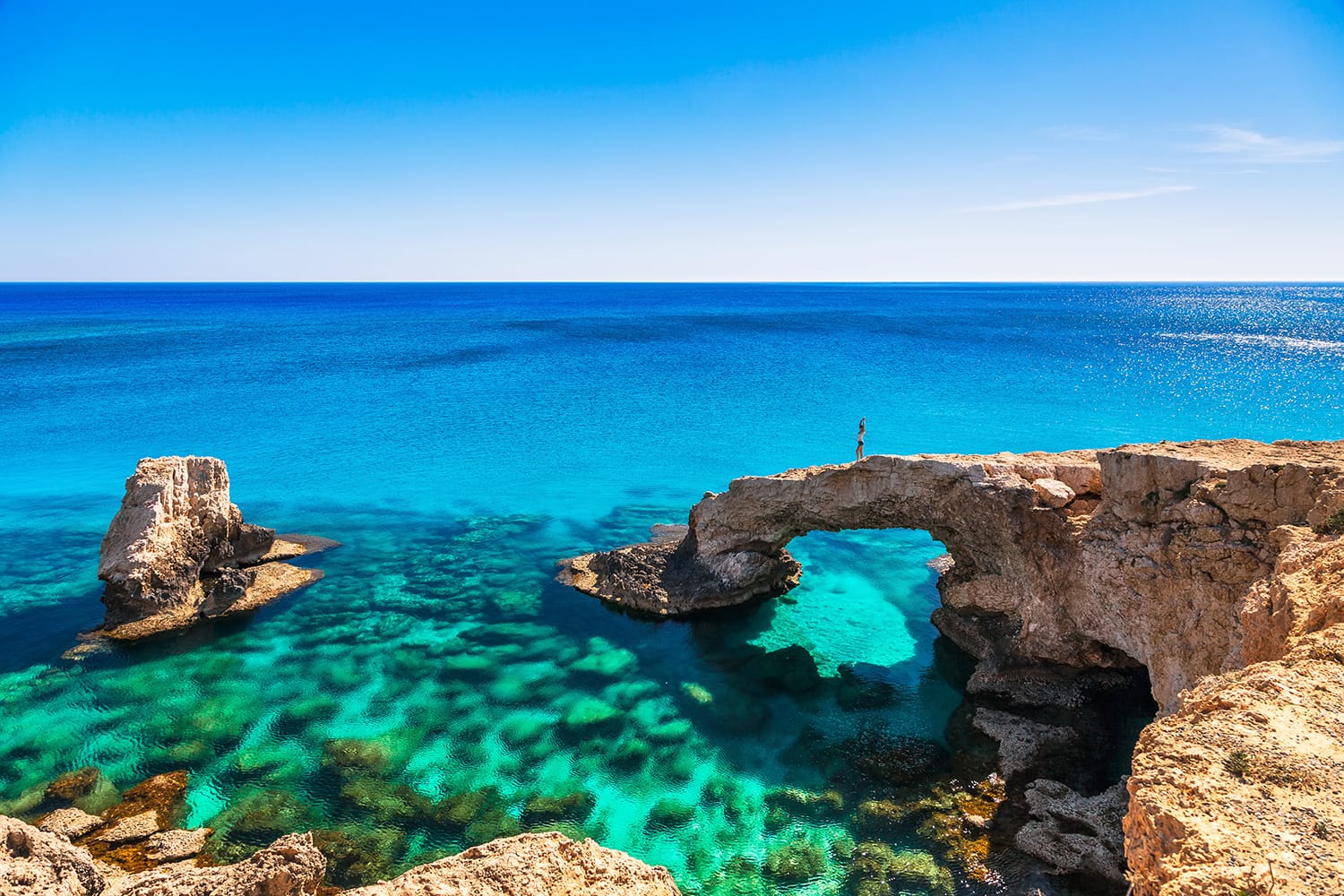 Woman on the beautiful natural rock arch near of Ayia Napa, Cavo Greco and Protaras on Cyprus island