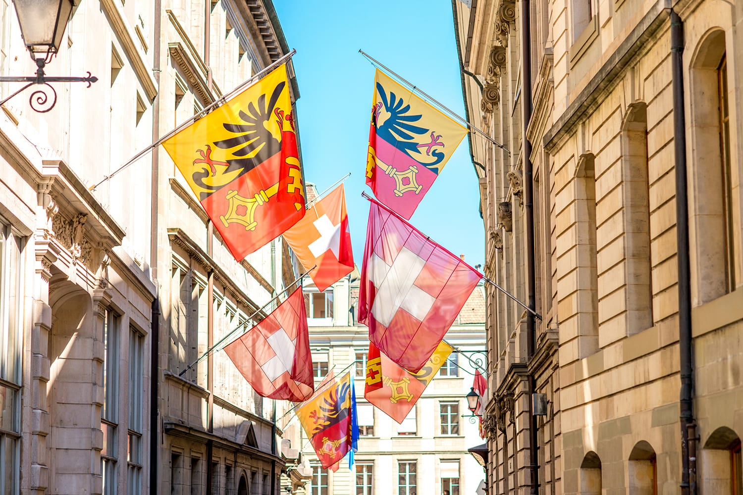 Street view with Swiss flags on the buildings in the old town of Geneva city in Switzerland