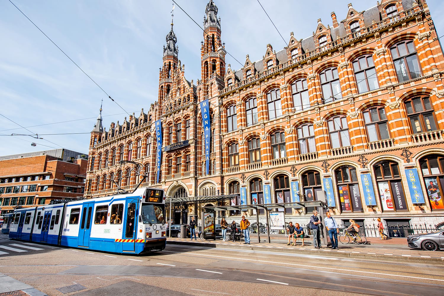 View on the crowded street with Magna Plaza. This building is the Former Amsterdam main post office, currently a shopping mall