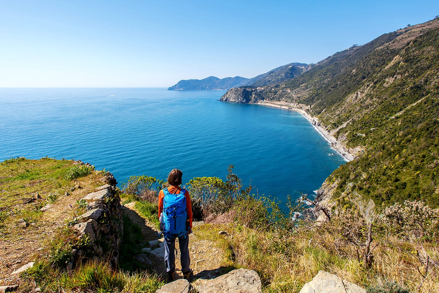 Woman with backpack admiring the view in Cinque Terre, Italy
