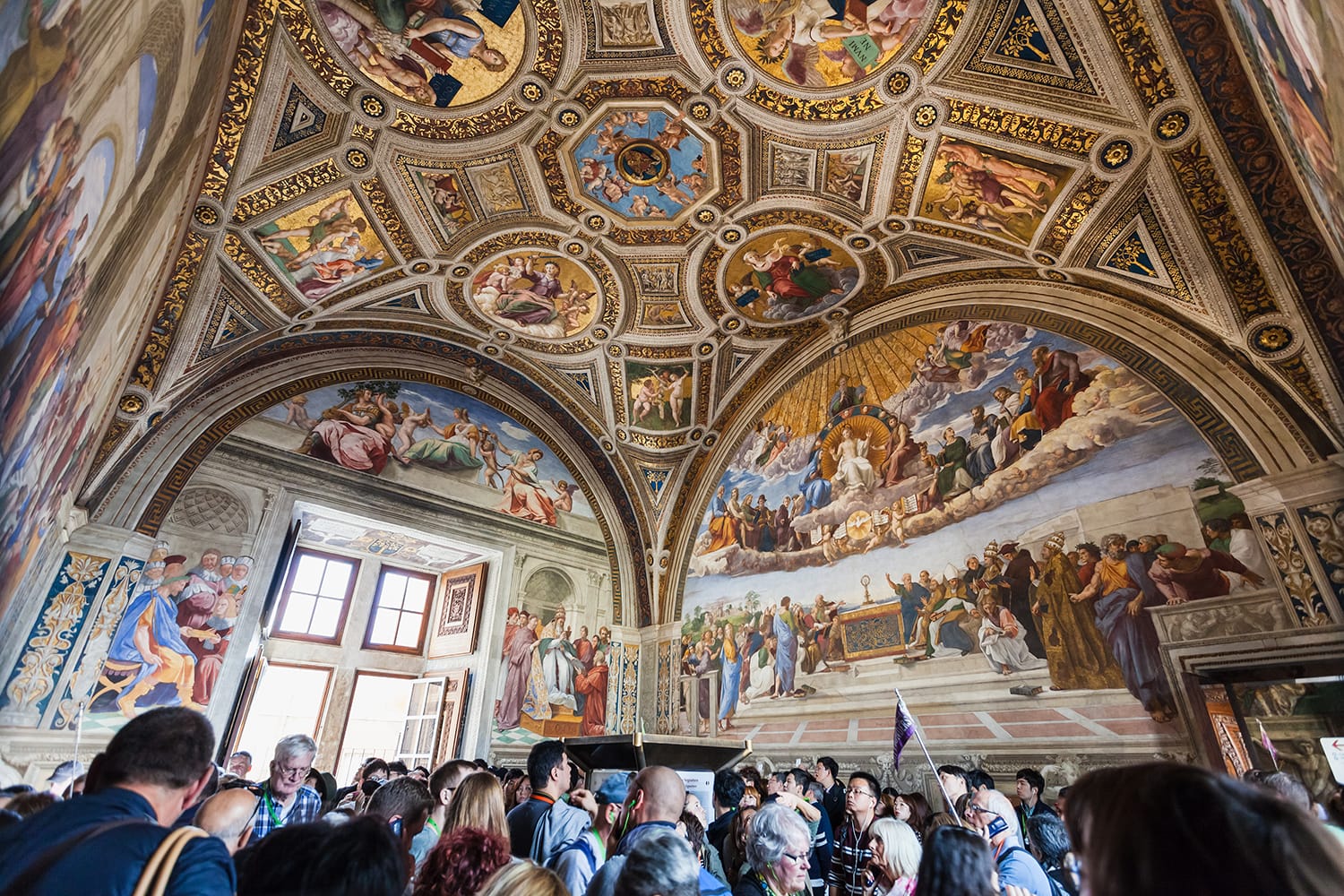 Visitors in Stanza della segnatura (Room of the Signatura) decorated by Raphael's frescoes in Raphael Rooms (Stanze di Raffaello) of Vatican museums, Rome, Italy