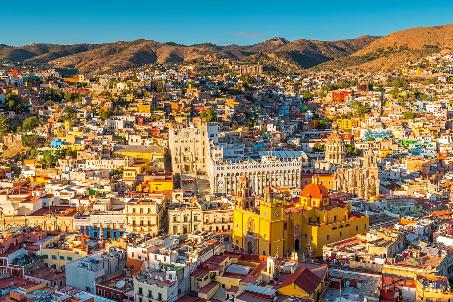 The last sun rays of the day shining on the skyline of Guanajuato city at sunset, Mexico.
