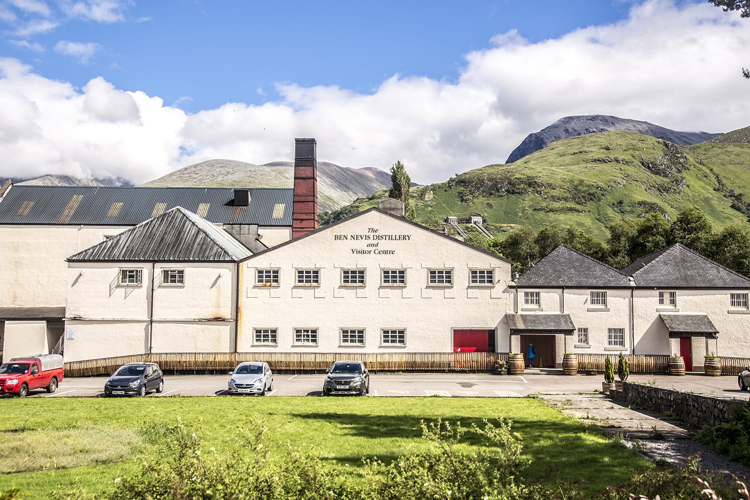 Ben Nevis distillery with Ben Nevis Mountain in background at Fort William, Scotland