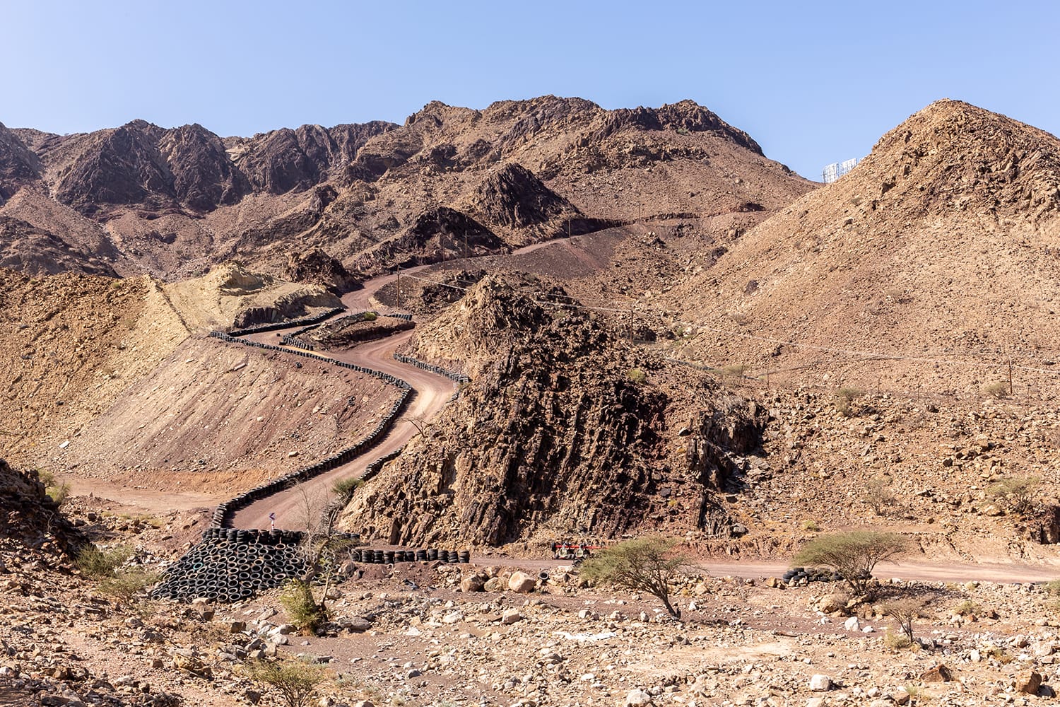 A man is hiking through a wadi in Hajar Mountains near Hatta, UAE