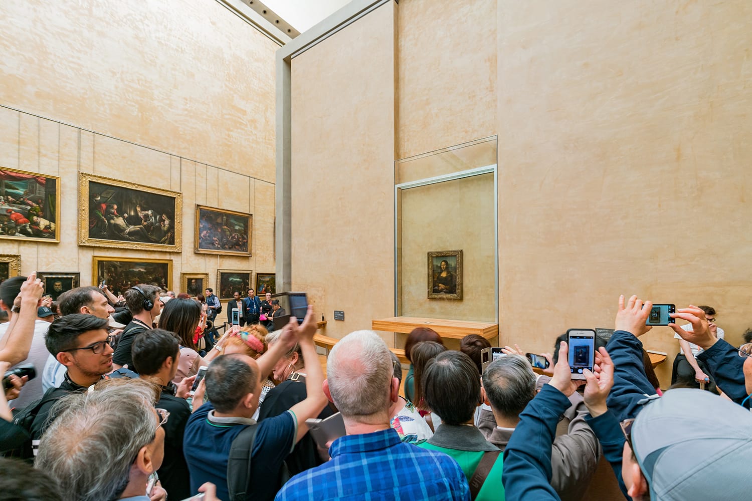 Tourist photographing the famous Mona Lisa painting in the Louvre Museum