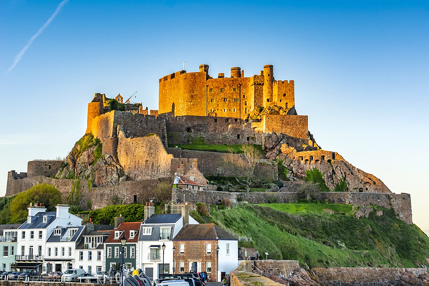 View of harbor town of Gorey with mount Orgueil Castle (Gorey Castle, built 1204 - 1450), overlooking Grouville Bay. Gorey, Jersey, Channel Islands, United Kingdom.