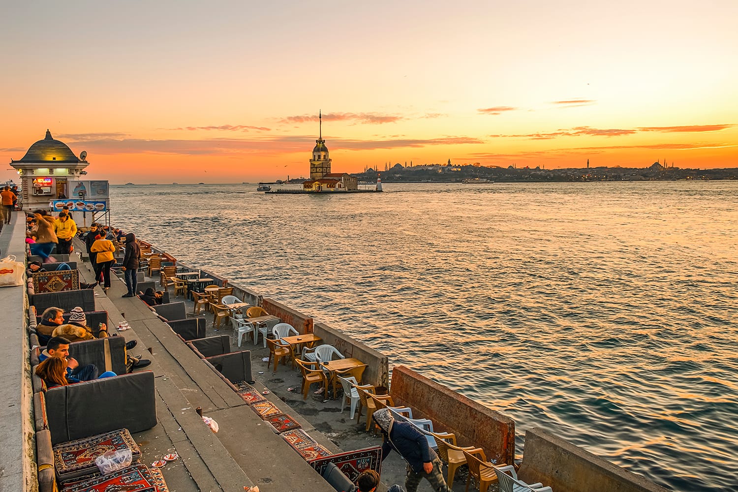 People enjoying the sunset with a view of the Maiden's tower in Istanbul, Turkey