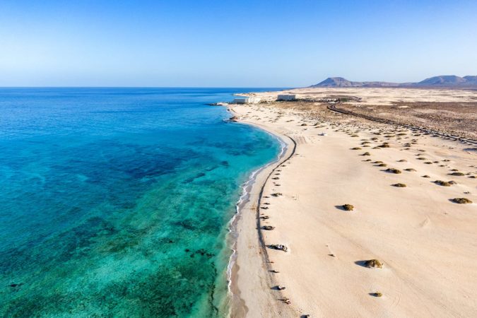 Panoramic high angle aerial drone view of Corralejo National Park (Parque Natural de Corralejo) with sand dunes located in the northeast corner of the island of Fuerteventura, Canary Islands, Spain.