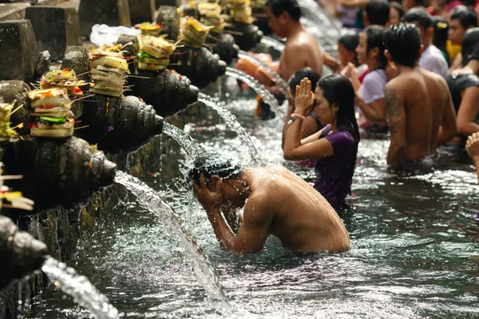 A Balinese people pray and make a ritual purification in holy springs of Tirta Empul Temple in Bali