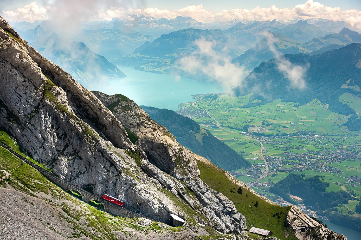 Red cogwheel train on Mount Pilatus and lake view