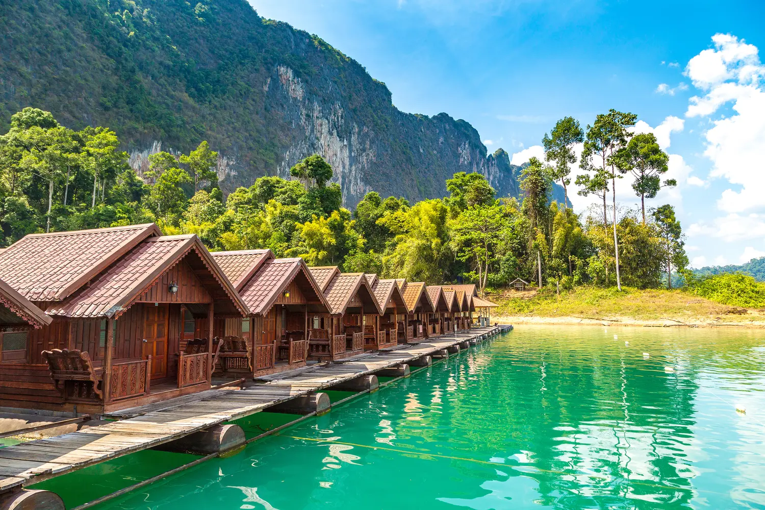 Traditional Thai bungalows at Cheow Larn lake, Ratchaprapha Dam, Khao Sok National Park in Thailand in a summer day