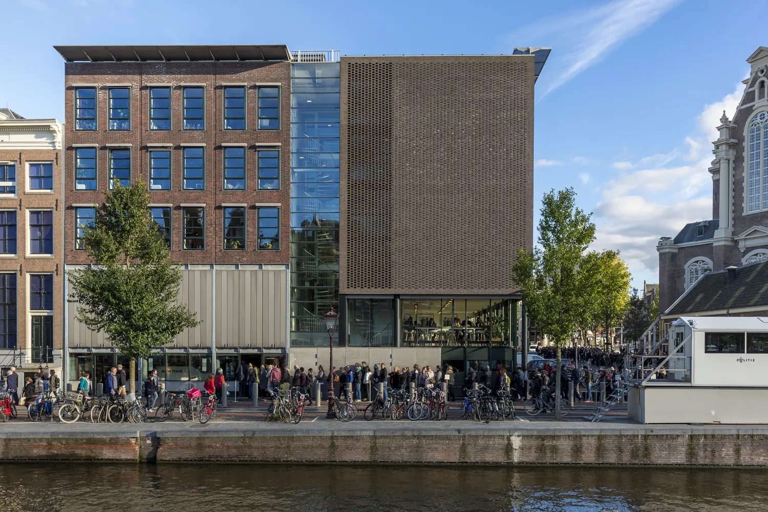 Amsterdam, Netherlands - October 10, Long waiting line in front of the ticket office to enter the Anne Frank house and war museum seen from the other side of the canal in Amsterdam