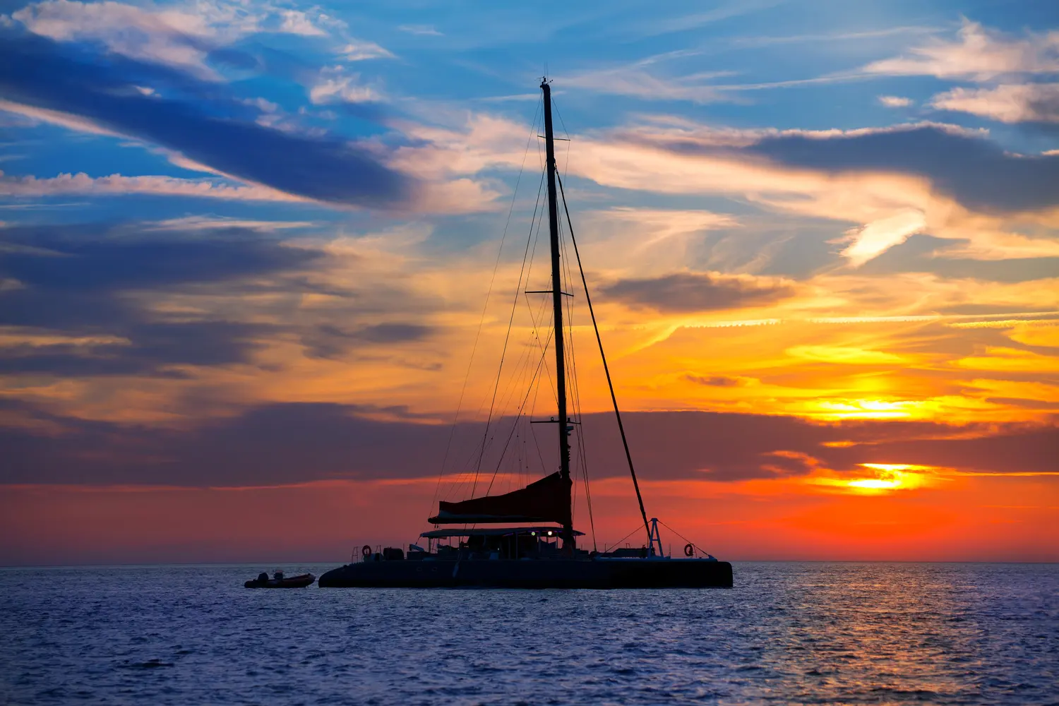 Catamaran sailboat during sunset