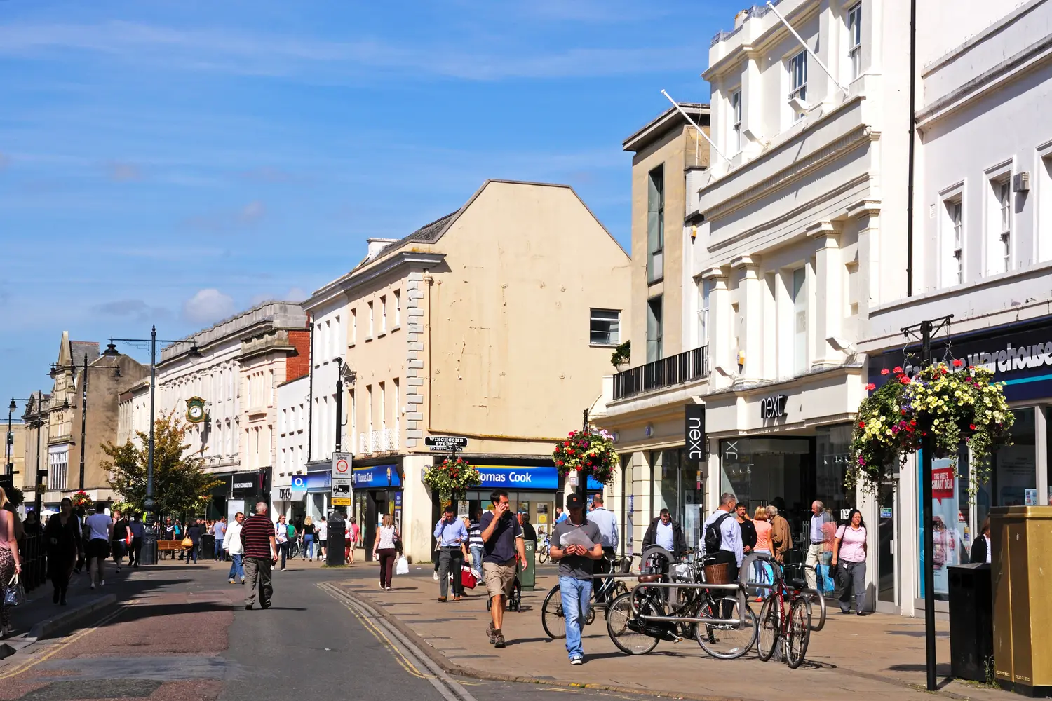 Shops with shoppers and tourists along the High Street, Cheltenham.