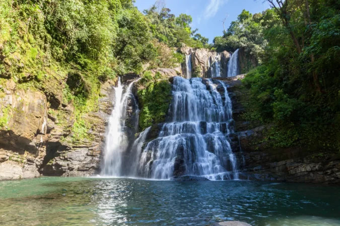 Nauyaca waterfalls with a deep swimming hole and large rocks in the south pacific of Costa Rica