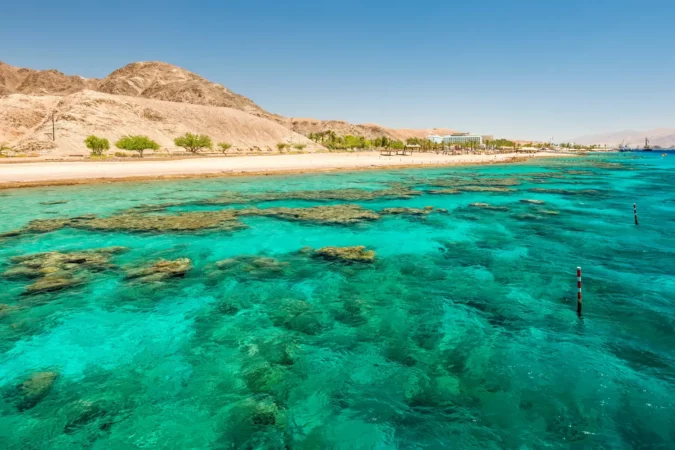Beautiful coral reefs of the Red Sea, sandy beaches, tourist hotels and mountains near Eilat, Israel.