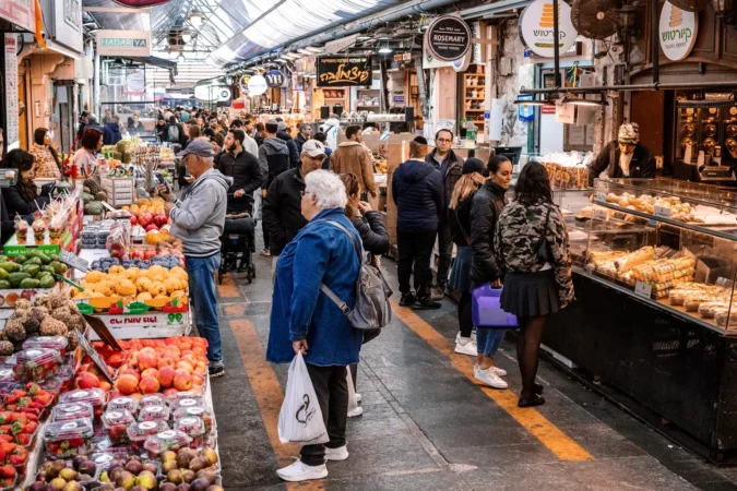 People shopping at Mahane Yehuda Market, often referred to as "The Shuk", is a marketplace in Jerusalem.