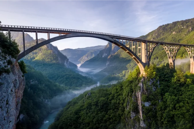 Beautiful misty morning view of Djurdjevica bridge over the river Tara in Montenegro