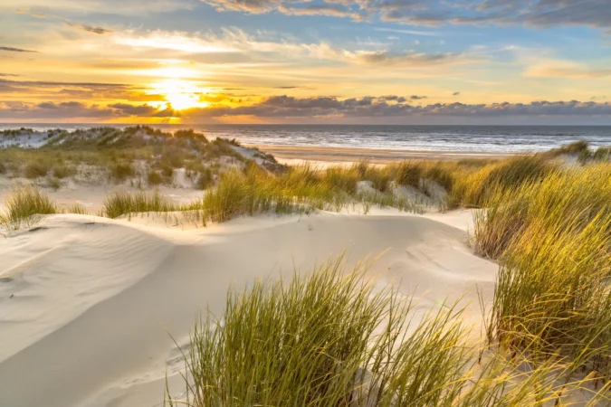 View from dune top over sunset in North Sea from the island of Ameland, Friesland, Netherlands