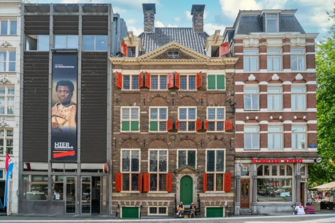 Tourist Sitting on the stairs of the Rambrandt house museum in Amsterdam