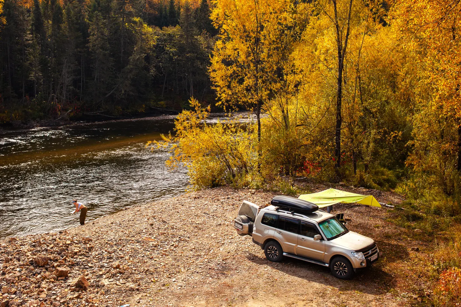 Car camping by the river in autumn