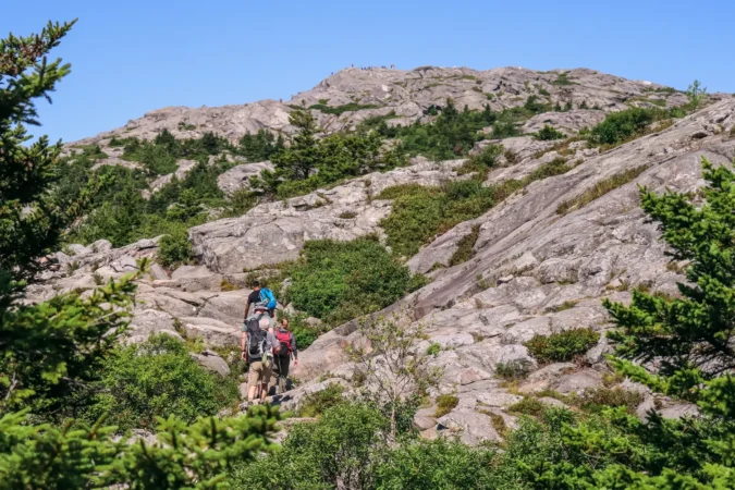 A small group of hikers ascending Mount Monadnock, at Monadnock State Park in New Hampshire.
