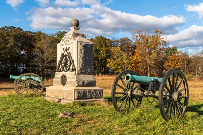 A Union monument and civil war cannons in the Wheatfield on the Gettysburg National Military Park on a sunny fall day