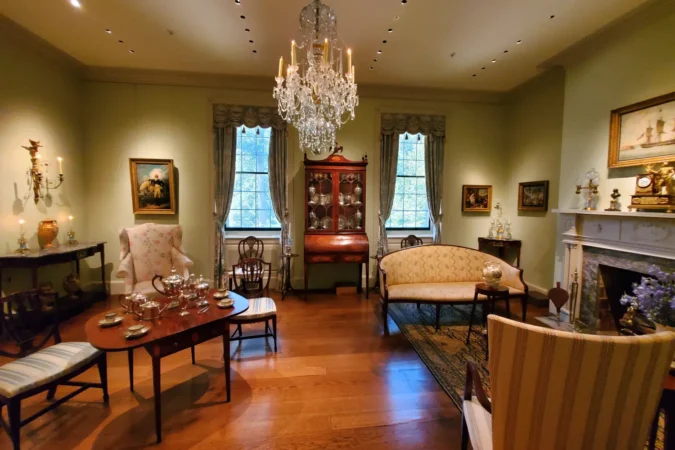 An elegant room with collection of ornate furniture and crystal chandelier inside of Winterthur Museum in Delaware