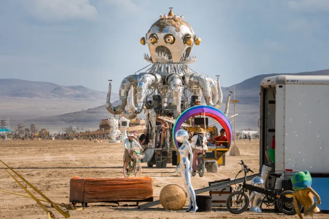 A large metallic robot with octopus like arms stands in the Nevada desert for Burning Man